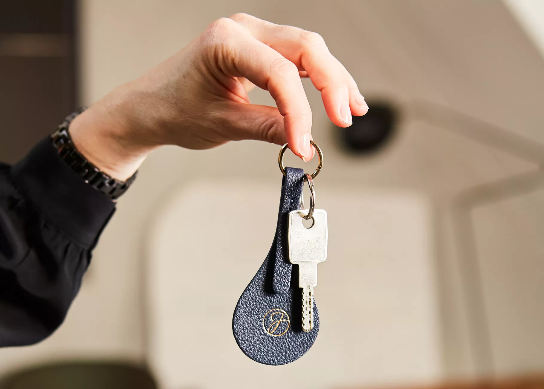 Hand holding keys on a Junot keyring